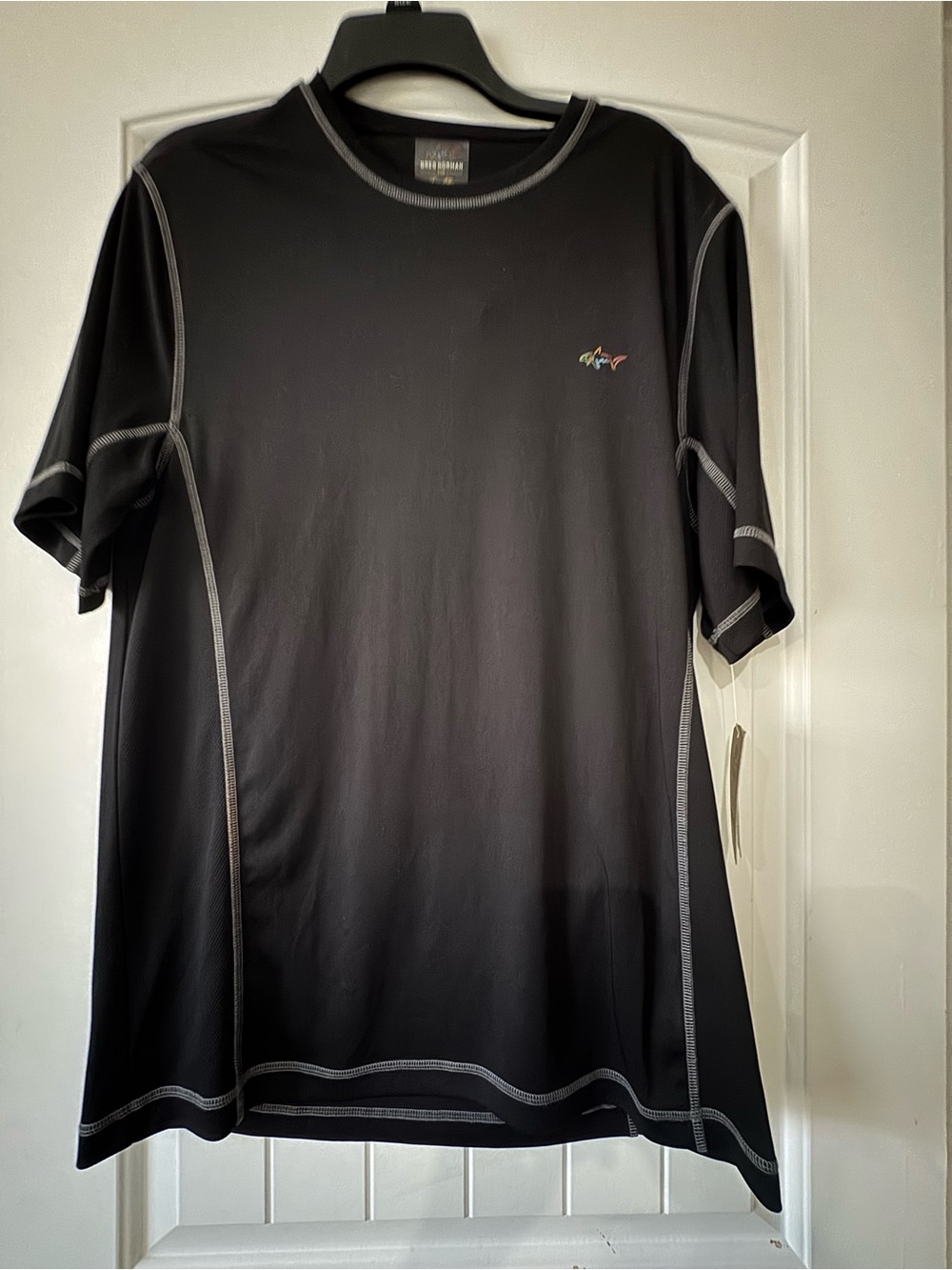 Greg Norman Collection Black Performance Tee with Multicolor Shark Logo